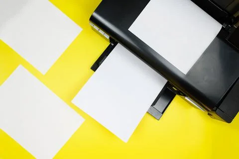 Top view of the printer and blank sheets of paper on a yellow background Stock Photos