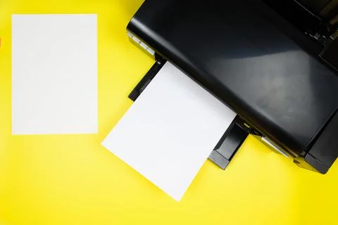 Top view of printer and blank sheets of a4 paper on yellow background Stock Photos