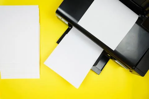 Top view of the printer and blank sheets of paper on a yellow background Stock Photos