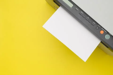 Top view of the printer and a blank sheet of a4 paper on a yellow background Stock Photos