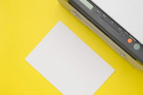 Top view of the printer and a blank sheet of a4 paper on a yellow background Stock Photos