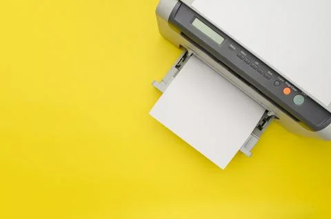 Top view of the printer and a blank sheet of a4 paper on a yellow background Stock Photos