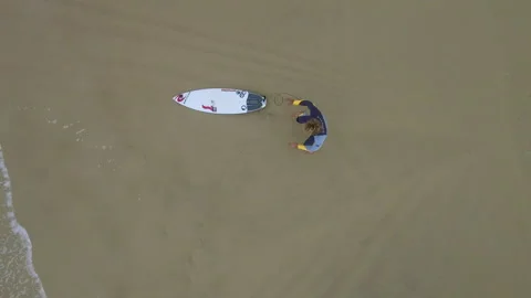 Top view of Pro surfer Alessandro Marciano on beach warming up and stretching Video stock 157104086