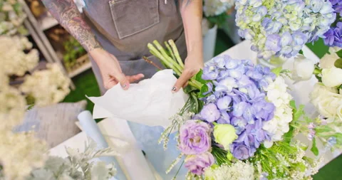 Top view of Professional florist create a beautiful bouquet of blooming flowers. Stock Footage 201018771