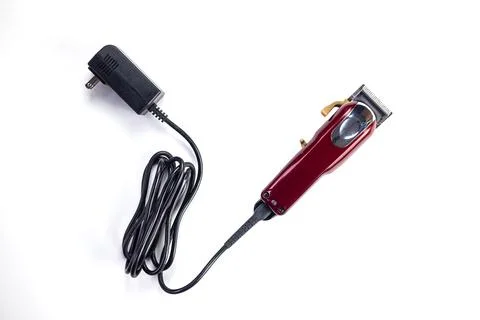 Top view of professional single red corded electric hairclipper on white ba.. Stock Photos