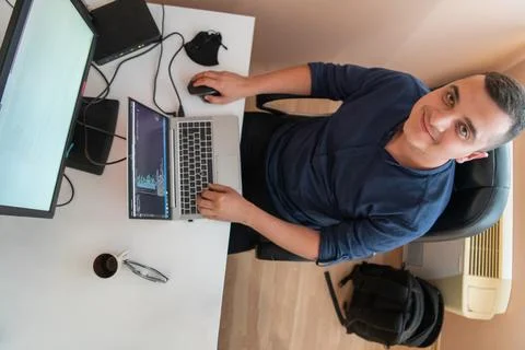 Top view of programmer diligently testing smartphone applications while sitting 스톡 사진