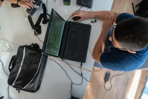 Top view of programmer diligently testing smartphone applications while sitting Stock Photos