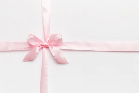 Top view of purple ribbon rolled and pink bow isolated on colored background. Stock Photos