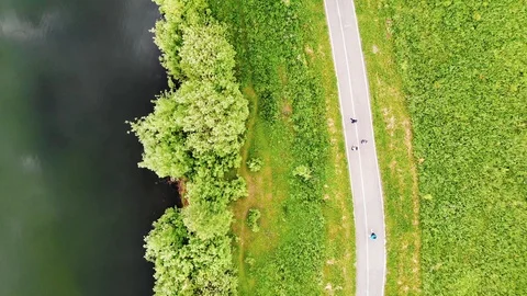 Top view from quadcopter to path along lake with people walking on her people 4K Stock Footage 122704396