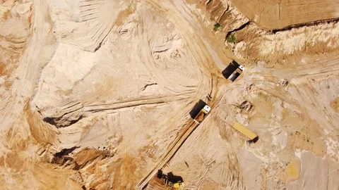Top view from quadcopter to wheel loader and dump trucks in quarry Stock Footage 163375434