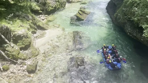 Top view of rafting team paddling through wild river with rocks and forest Vídeos de archivo 342025706