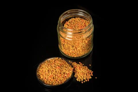 Top view of raw bee pollen grain in cover next to pollen jar Фото