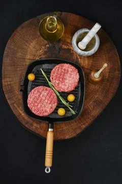 Top view of raw beef burger cutlet on frying pan Stock Photos
