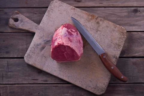 Top view raw beef meat on cutting board and knife on wooden background Stock Photos