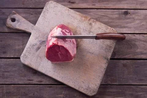 Top view raw beef meat on cutting board and knife on wooden background Stock Photos