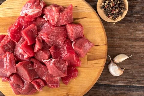 Top view of raw beef or lamb meat, garlic cloves and a mixture of peppers. Stock Photos