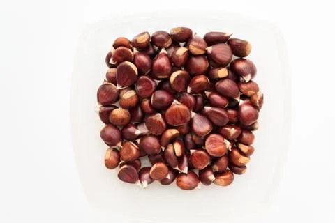 Top view of raw chestnuts on container on white background Stock Photos