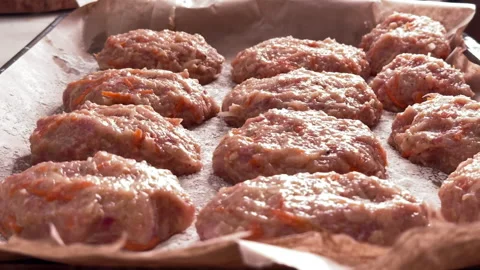 Top view of raw chicken and vegetable cutlets on a baking tray Stock Footage 304799993