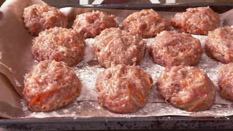 Top view of raw chicken and vegetable cutlets on a baking tray Stock-Footage 304800100