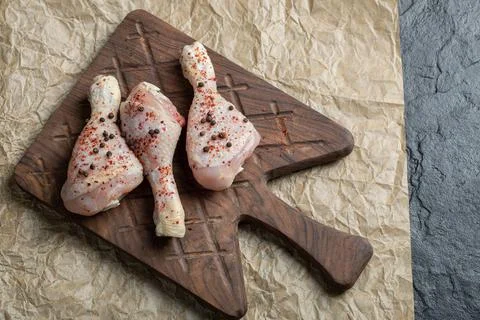 Top view raw chicken drumstick and spices on food paper Stock Photos