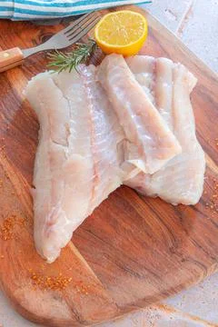 Top view of raw coal fish fillet with spices and herbs on wooden board Stock Photos