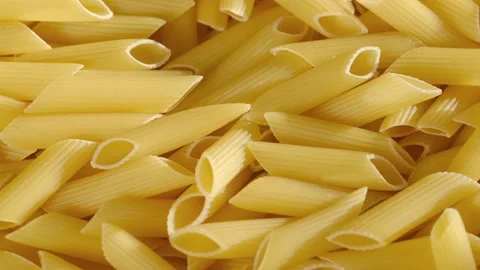 Top view of raw fresh pasta penne rigate rotate on tray. Penne Rigate macaroni Stock Footage 170349357
