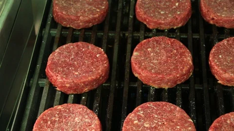 Top view of raw hamburger patties sitting on a hot char broiler grill Stock Footage 127715943