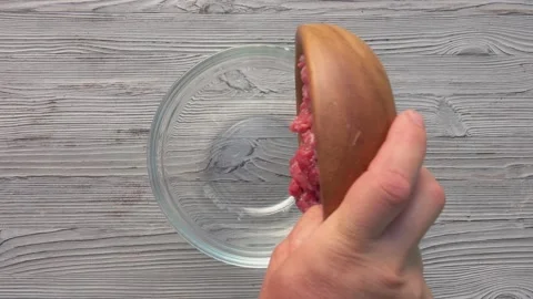 Top view of the raw minced meat falling in a glass bowl Stock Footage 144176570