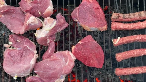 Top view of raw red meat steaks and sausages grilled on charcoal grill Stock-Footage 200493723