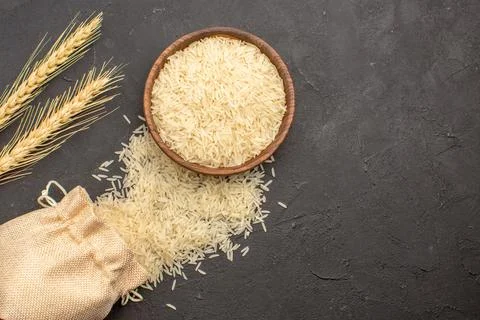 Top view raw rice inside brown plate on grey background rice raw food east .. Stock Photos