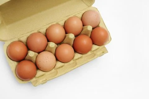 Top view of raw rustic brown eggs in a green paper box. Stock Photos
