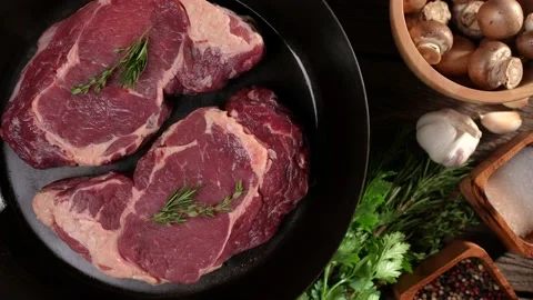 Top view of raw steak beef meat on a turntable pan on a wooden table Stock Footage 170314951