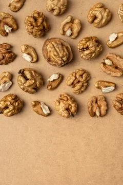 Top view of raw walnut kernels scattered on brown background. Natural healthy Stock Photos