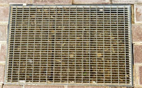 Top view of a rectangular metal drainage grate and scraper mat embedded in .. Stock Photos