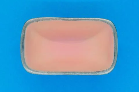 Top view of rectangular pink empty dish with silver edges on blue background Foto stock