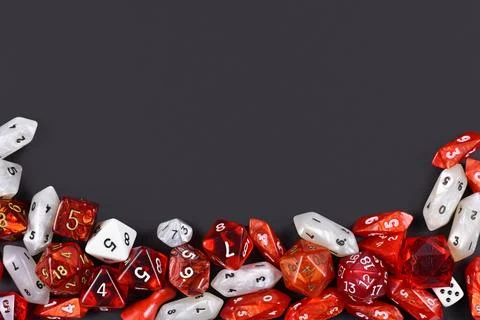 Top view of red and white role playing RPG dice of different shape on black Fotos de archivo