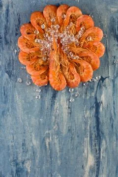 Top view of Red Argentinian prawns with ice on a blue background. Stockfoto's