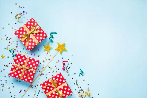 Top view of a red dotted gift boxes, golden magic wands, colorful confetti .. Stock Photos