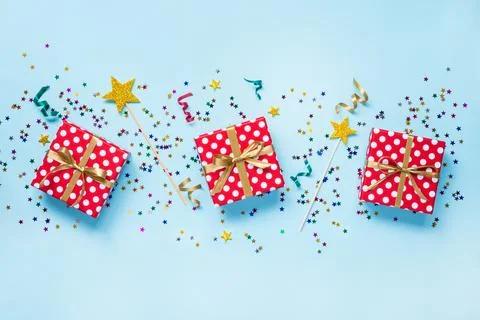 Top view of a red dotted gift boxes, golden magic wands, colorful confetti .. Stock Photos
