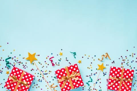Top view of a red dotted gift boxes, golden magic wands, colorful confetti .. Stock Photos
