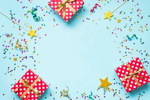 Top view of a red dotted gift boxes, golden magic wands, colorful confetti .. Stock Photos