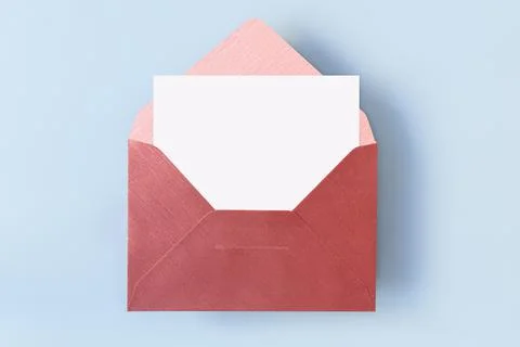 Top view of red envelope with empty blank white card on light blue background Фото