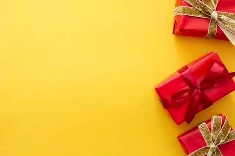 Top view of red gift boxes with ribbon over colorful yellow background. Valen Stock Photos