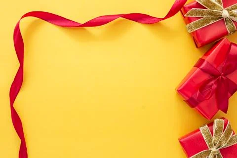 Top view of red gift boxes with ribbon over colorful yellow background. Valen Foto stock