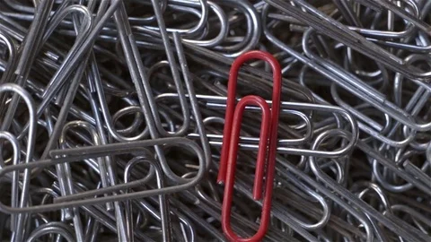Top view of red paper clip on other gray. Rotate Stock Footage 72054482