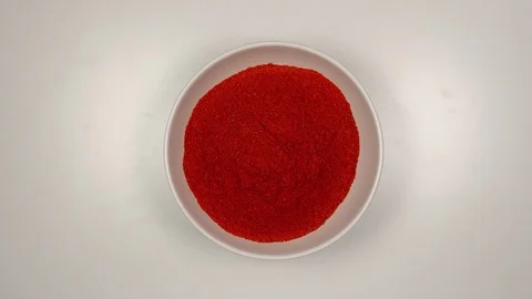 TOP VIEW: Red pepper powder fill a white dish - Stop motion Stock Footage 90239805