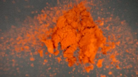 TOP VIEW: Red pepper powder falling and splashing on a black table - Slow Motion Stock Footage 90240110