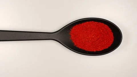TOP VIEW: Red pepper powder fill a plastic spoon on a table - Stop motion Видео 92578102