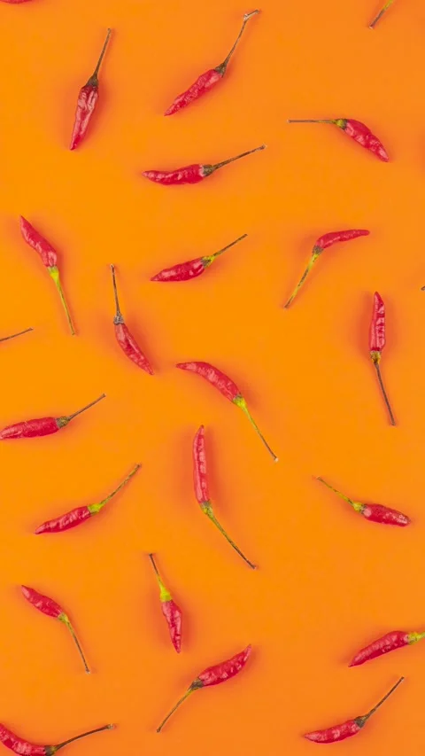 Top view of red peppers over orange background. High contrast backdrop Stock Footage 273715513