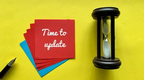 Top view of red sticky note with time to update text. With minutes glasses and Stock Photos